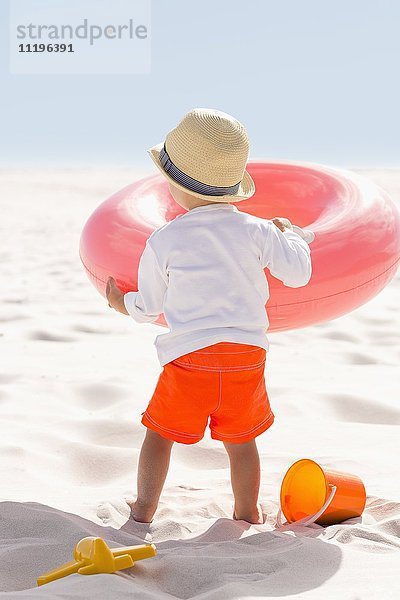Rückansicht eines am Strand spielenden Jungen