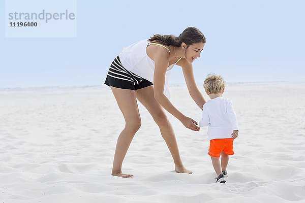 Frau spielt mit ihrem Sohn am Strand