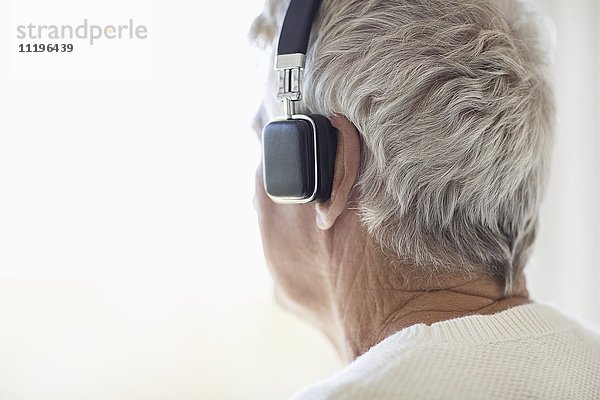 Senior Mann hört Musik über Kopfhörer