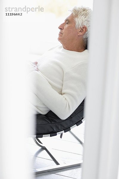 Senior Mann schläft auf Stuhl