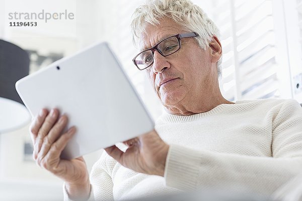 Älterer Mann mit einem digitalen Tablett