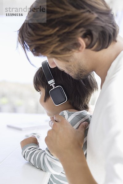 Junge hört Musik mit Kopfhörer mit Vater