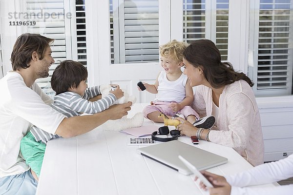 Glückliche junge Familie beim Spielen zu Hause