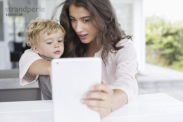 Mutter und Sohn nehmen Selfie mit digitalem Tablett mit nach Hause
