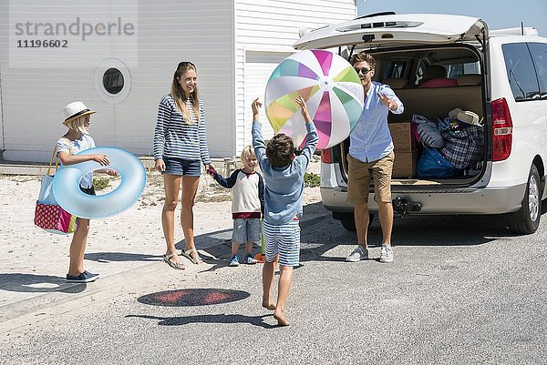 Fröhliches junges Familienpackauto mit Strandgetriebe für den Urlaub