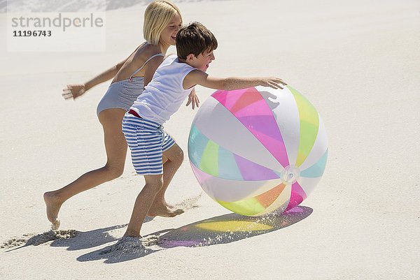 Kinder beim Spielen am Strand mit einem Ball