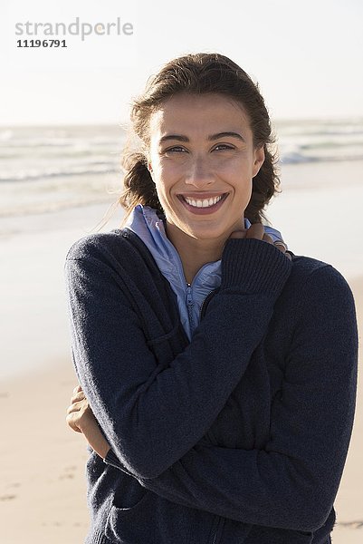 Porträt einer glücklichen schönen Frau  die am Strand steht