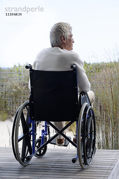 Senior im Rollstuhl entspannt im Freien