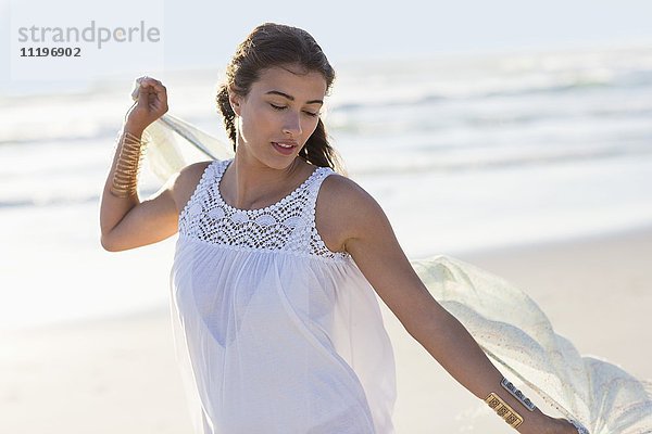 Schöne junge Frau genießt am Strand