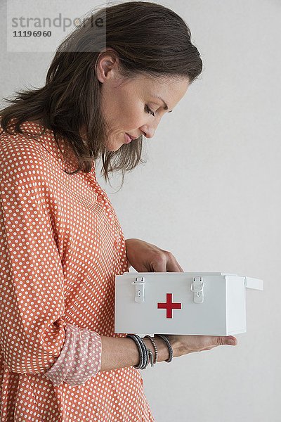 Reife Frau mit Erste-Hilfe-Kasten