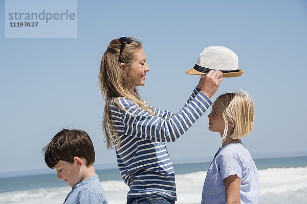 Seitenprofil einer Frau mit ihren Kindern am Strand