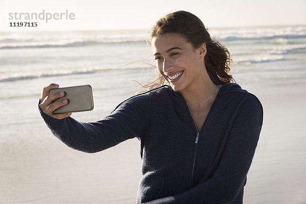 Frau fotografiert sich mit einem Smartphone