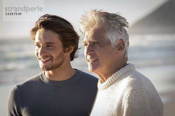 Glücklicher Vater und Sohn stehen am Strand