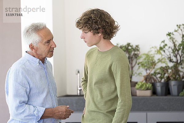 Ein älterer Mann im Gespräch mit seinem jugendlichen Enkel.