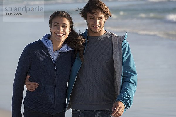 Glückliches junges Paar genießt am Strand