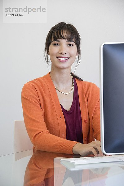 Glückliche Geschäftsfrau bei der Arbeit am Computer im Büro