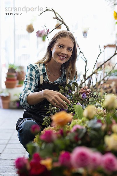 Porträt einer Floristin lächelnd in ihrem Geschäft