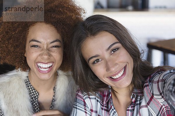 Porträt von glücklichen Freundinnen  die Spaß im Cafe haben