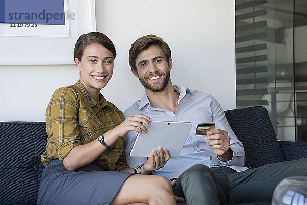 Glückliches Paar beim Online-Shopping auf dem digitalen Tablett