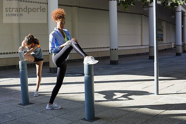 Junge Sportlerinnen beim Stretching im Freien