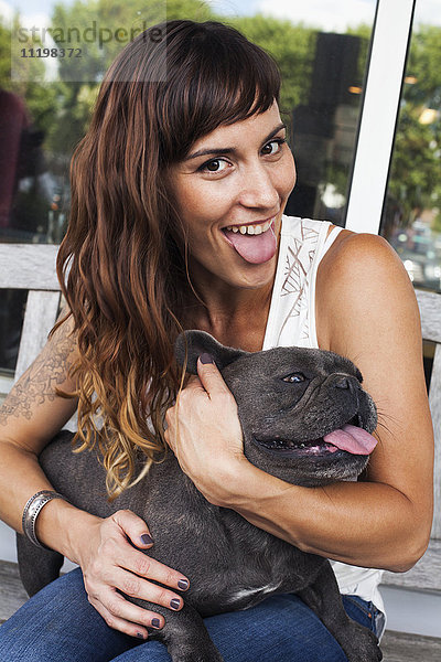 Kaukasische Frau imitiert Hund mit herausgestreckter Zunge