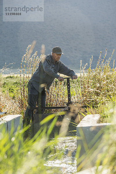 Kaukasischer Landwirt beim Einstellen der Bewässerungsanlage