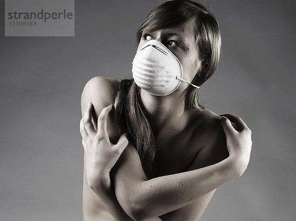 Nackte kaukasische Frau mit Verschmutzungsmaske
