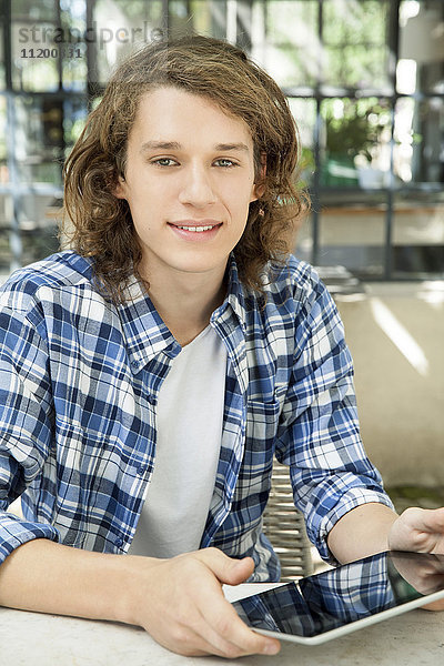Junger Mann mit digitalem Tablett im Freien