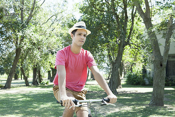 Junger Mann auf dem Fahrrad durch die bewaldete Landschaft