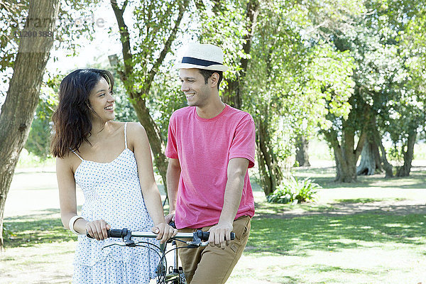 Junges Paar geht mit dem Fahrrad spazieren