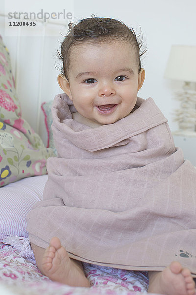 Baby im Handtuch gewickelt  lächelnd  Portrait