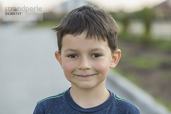 Porträt eines lächelnden Jungen an der Straße stehend