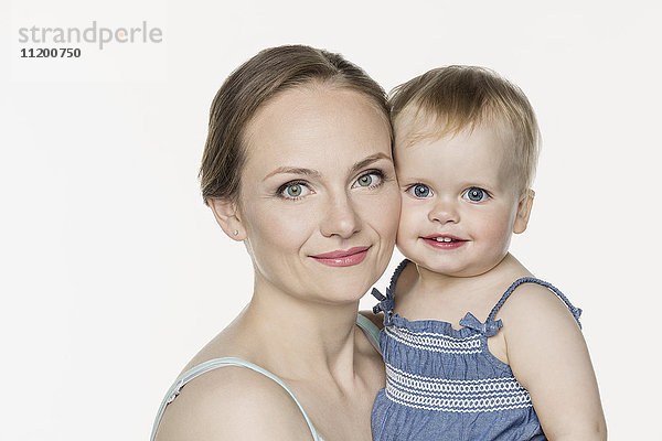 Porträt der lächelnden Mutter mit süßem Mädchen vor weißem Hintergrund