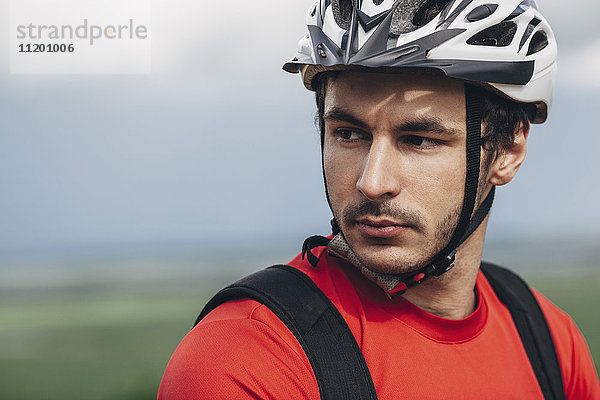 Porträt eines selbstbewussten Mannes mit Fahrradhelm