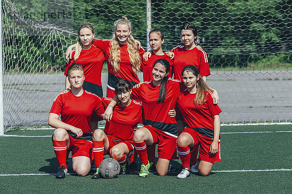 Porträt der Fußballmannschaft auf dem Feld gegen das Netz