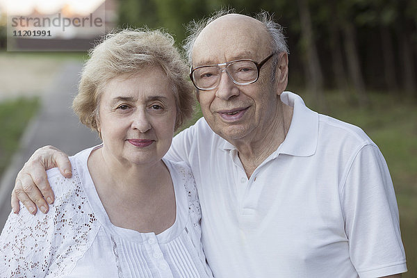 Porträt eines lächelnden Seniorenpaares im Park