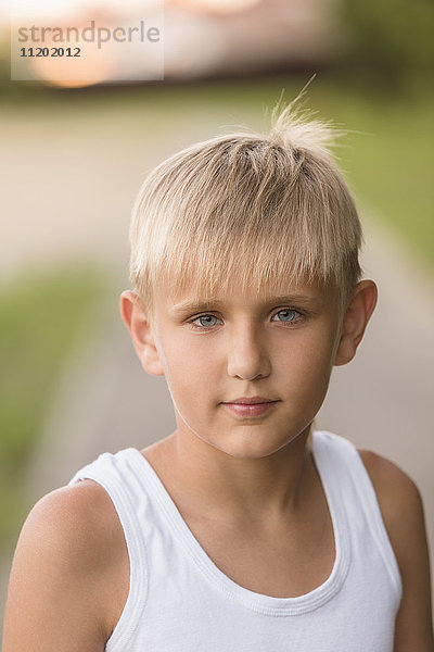 Porträt eines selbstbewussten Jungen mit grauen Augen im Park