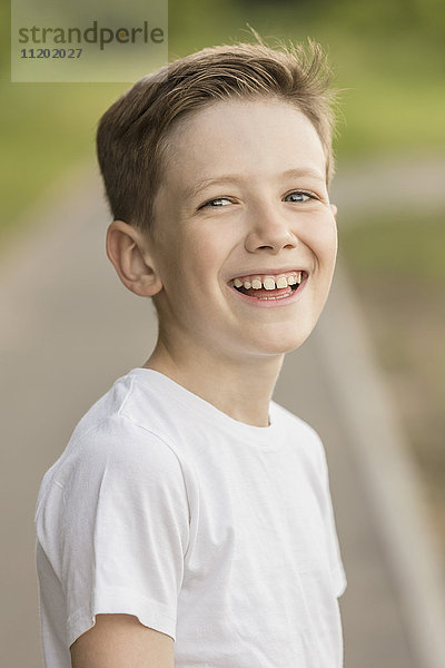 Porträt des fröhlichen Jungen im Park