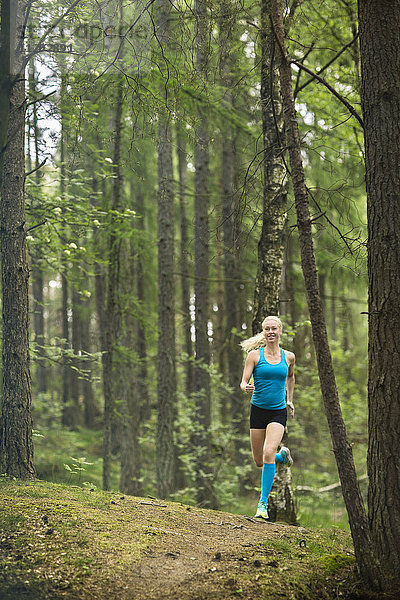 Frau läuft im Wald