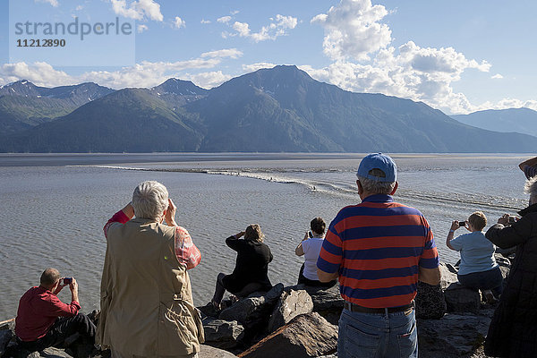 Eine Gruppe von Menschen beobachtet  wie eine kleine Flut an ihnen vorbeizieht  während sie von einem Rastplatz am Seward Hwy aus zusehen  Süd-Zentral-Alaska  USA