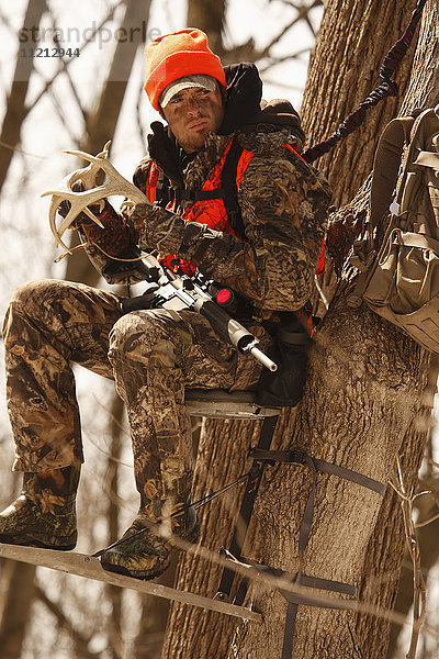 Whitetail Deer Hunter In Treestand
