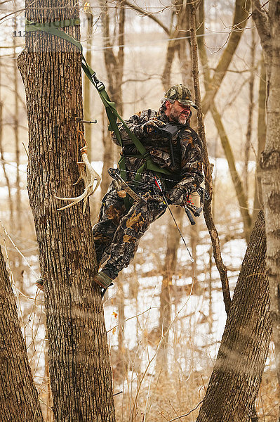Jäger im Baumsattel Baumstand im Winter während einer Hirschjagd