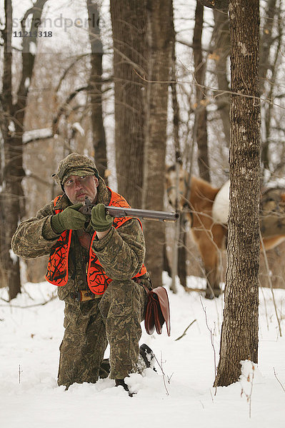 Vorderladerjäger mit Pferd auf der Jagd im Winter