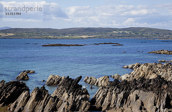 Zerklüftete Felsen entlang der Küstenlinie mit Hügeln in der Ferne  in der Nähe von Eyeries; Grafschaft Cork  Irland'.