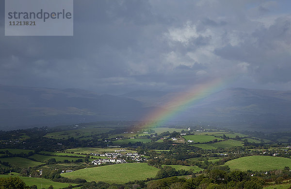 Ein Regenbogen über saftigen Feldern unter den Gewitterwolken  in der Nähe von Bantry; Grafschaft Cork  Irland '