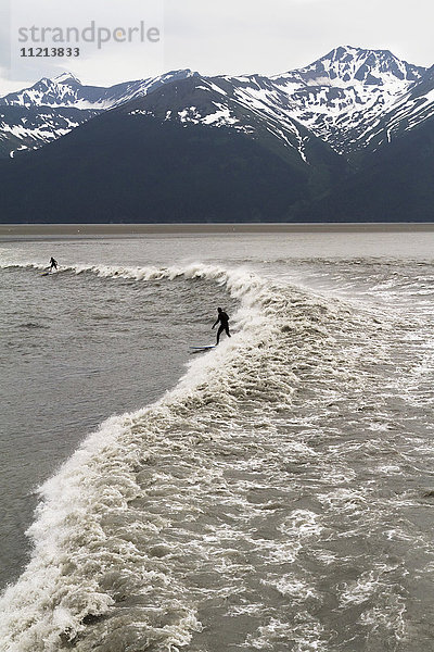 Surfer reiten auf einer großen Flutwelle in Turnagain Arm  Süd-Zentral-Alaska  USA