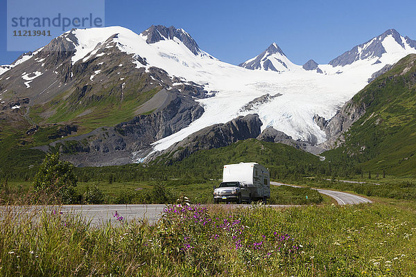 Ein Pickup zieht einen Wohnwagen den Richardson Hwy hinunter  im Hintergrund ist der Worthington Glacier zu sehen  Southcentral Alaska  USA