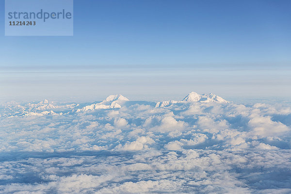 Luftaufnahme von zwei schneebedeckten Bergen in der Alaska Range  die aus den Wolken ragen  Anchorage  Southcentral Alaska  USA  Sommer