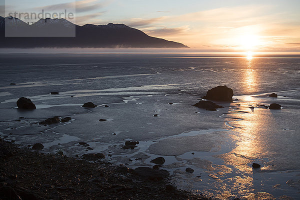 Sonnenuntergang über dem Wattenmeer von Turnagain Arm im Spätherbst; Süd-Zentral-Alaska; Alaska  Vereinigte Staaten von Amerika'.