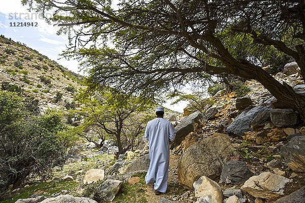 Mann in traditioneller Kleidung in den Ruinen des verlassenen Dorfes Al Roose  Jabal Akhdar